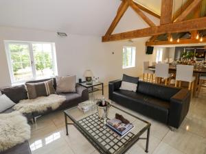 a living room with a couch and a table at Lower Tundridge Cottage in Suckley