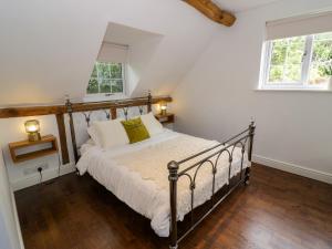 a bedroom with a bed and two windows at Lower Tundridge Cottage in Suckley