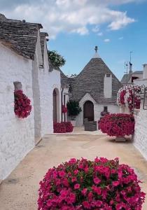 a white building with pink flowers in front of it at Apuliantales Cottage Bari in Carbonara di Bari