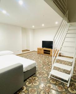a bedroom with a bed and a staircase and a television at Apuliantales Cottage Bari in Carbonara di Bari