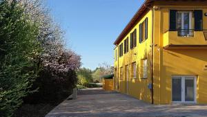 a yellow building with a driveway next to it at Casa del Falegname - Loft Rovere con cucina in San Giovanni in Bosco