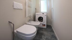 a bathroom with a toilet and a washing machine at Casa del Falegname - Loft Rovere con cucina in San Giovanni in Bosco