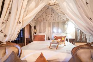 a bedroom with a bed with a canopy at Maison Lakala in Ben Slimane