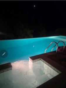 a large swimming pool at night with at Azure Theologos Villa in Theologos
