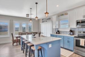 a kitchen with blue cabinets and a kitchen island with bar stools at Downtime in Padre Island