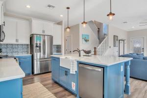 a kitchen with blue and white cabinets and a sink at Downtime in Padre Island