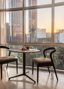 a table and two chairs in front of a window at Hyde Mexico City Reforma in Mexico City