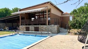 a house with a swimming pool in front of a house at Divna Pool&Garden 