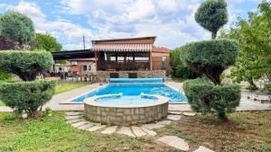 a swimming pool in front of a house at Divna Pool&Garden 