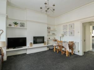 a living room with a television and a table with chairs at Northgate Ground Floor Flat in Hunstanton
