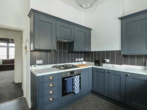 a kitchen with blue cabinets and a stove at Northgate Ground Floor Flat in Hunstanton