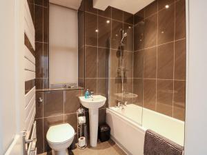 a bathroom with a toilet and a tub and a sink at Northgate Ground Floor Flat in Hunstanton +14 photos