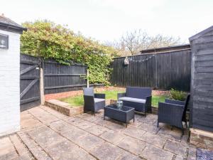a patio with chairs and a table and a fence at Northgate Ground Floor Flat in Hunstanton