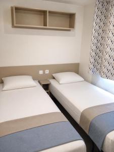 two beds in a small room with a window at Feel MH 54 in Gastes +11 photos
