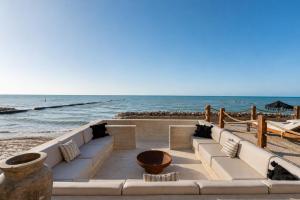 a couch on the beach with the ocean in the background at Luxury Villas By Awa Holbox - Beachfront in Holbox Island +2 photos