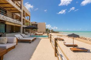 a resort with a pool and a beach with chairs and umbrellas at Luxury Villas By Awa Holbox - Beachfront in Holbox Island