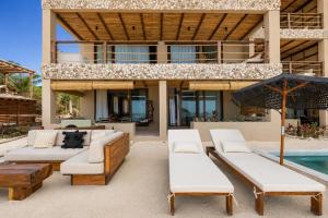 an outdoor patio with furniture and a swimming pool at Luxury Villas By Awa Holbox - Beachfront in Holbox Island