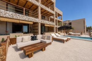 a patio with couches and a pool in front of a building at Luxury Villas By Awa Holbox - Beachfront in Holbox Island