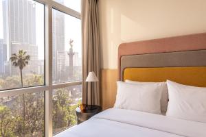 a hotel room with a bed and a large window at Hyde Mexico City Reforma in Mexico City