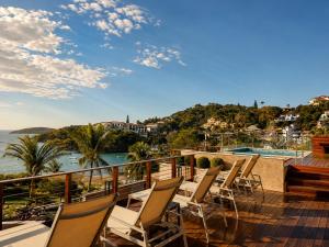 a balcony with chairs and a view of the water at HOTEL VILLE LA PLAGE & BEACH CLUB in Búzios +74 photos