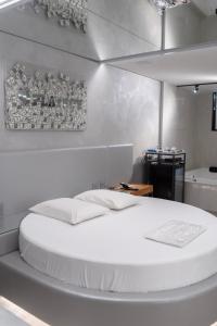 a white bedroom with a large white bed in it at Motel Cavalo Branco in Belo Horizonte +28 photos