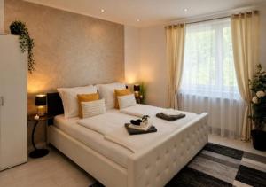 a large white bed in a room with a window at Deea Apartment in Schottwien