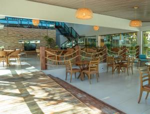 a restaurant with wooden tables and chairs in a building at Mansao in Maragogi