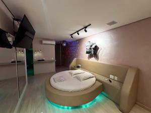 a bedroom with a round bed with a lightedvisor at Motel Cavalo Branco in Belo Horizonte