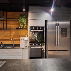 a kitchen with a stainless steel refrigerator and a sink at RioDowntown Hub by RNC Flats in Rio de Janeiro