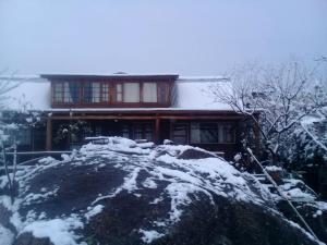 a house covered in snow in front at CABAÑAS BALCON DE PEHUMAYEN in Villa Carlos Paz