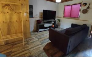 a living room with a couch and a flat screen tv at Hospedaje Naomi in Valparaíso