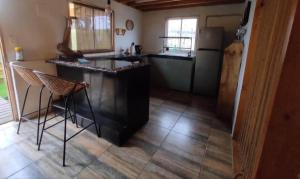 a kitchen with a counter and some chairs in it at Hospedaje Naomi in Valparaíso