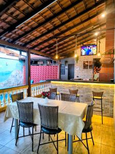 a dining room with a table and chairs in a restaurant at Refúgio Alemar in Ribeirão Preto