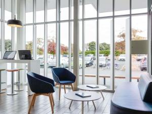 a room with two chairs and a table and windows at ibis Budget Auckland Airport in Auckland