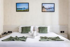 a bedroom with a white bed with three pictures on the wall at Marmaris Saray Hotel DOWNTOWN in Tashkent