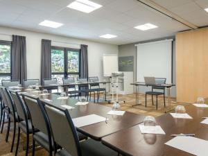 a conference room with tables and chairs and a whiteboard at ibis Brignoles Provence Verte in Brignoles +100 photos