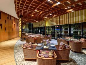 a restaurant with tables and chairs in a room at Pullman New Delhi Aerocity in New Delhi