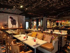 a restaurant with tables and chairs and a chicken on the ceiling at Mama Shelter Bordeaux Centre in Bordeaux