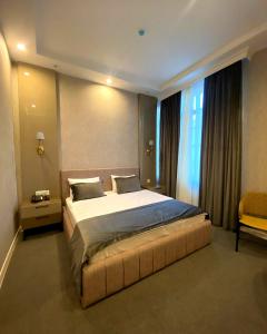 a bedroom with a large bed and a window at Northern City Hotel in Zaqatala