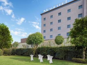 a row of white chairs in front of a hotel at Novotel Brescia Due in Brescia