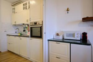 a kitchen with white cabinets and a microwave at Il Brigantino in Cori