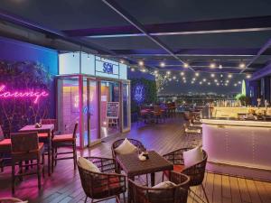 a restaurant with tables and chairs and a bar at Ibis Saigon Airport in Ho Chi Minh City