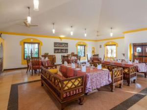 a restaurant with tables and chairs in a room at Novotel Goa Dona Sylvia Resort in Cavelossim
