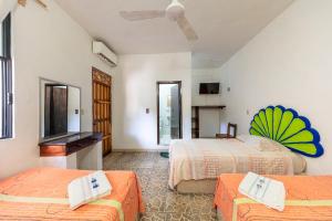a hotel room with two beds and a flat screen tv at Hotel Naxhiely in Puerto Escondido