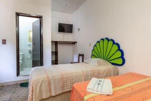 a hotel room with two beds and a bathroom at Hotel Naxhiely in Puerto Escondido