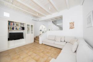 a white living room with a white couch and a tv at Villa Loka in Gennadi