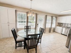a dining room with a glass table and chairs at Embrace The Outdoors In This Modern Rydal Setting in White
