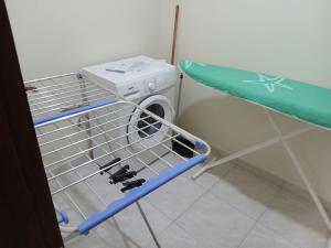 a drying rack in a room with a washing machine at Salão Zuzu in Ribeira Grande
