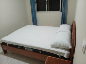 a small bed in a room with a window at Salão Zuzu in Ribeira Grande