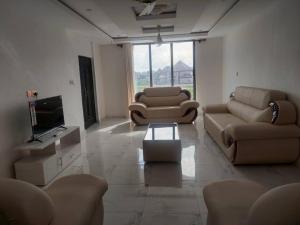 a living room with couches and a flat screen tv at Monroe Luxury Apartments in Nsima